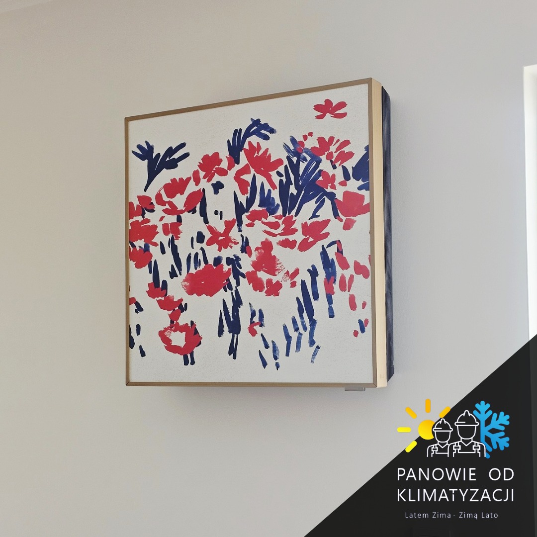 Klimatyzator ścienny z artystycznym panelem frontowym w kolorach czerwieni i granatu, imitujący malarską kompozycję kwiatową na białym tle.