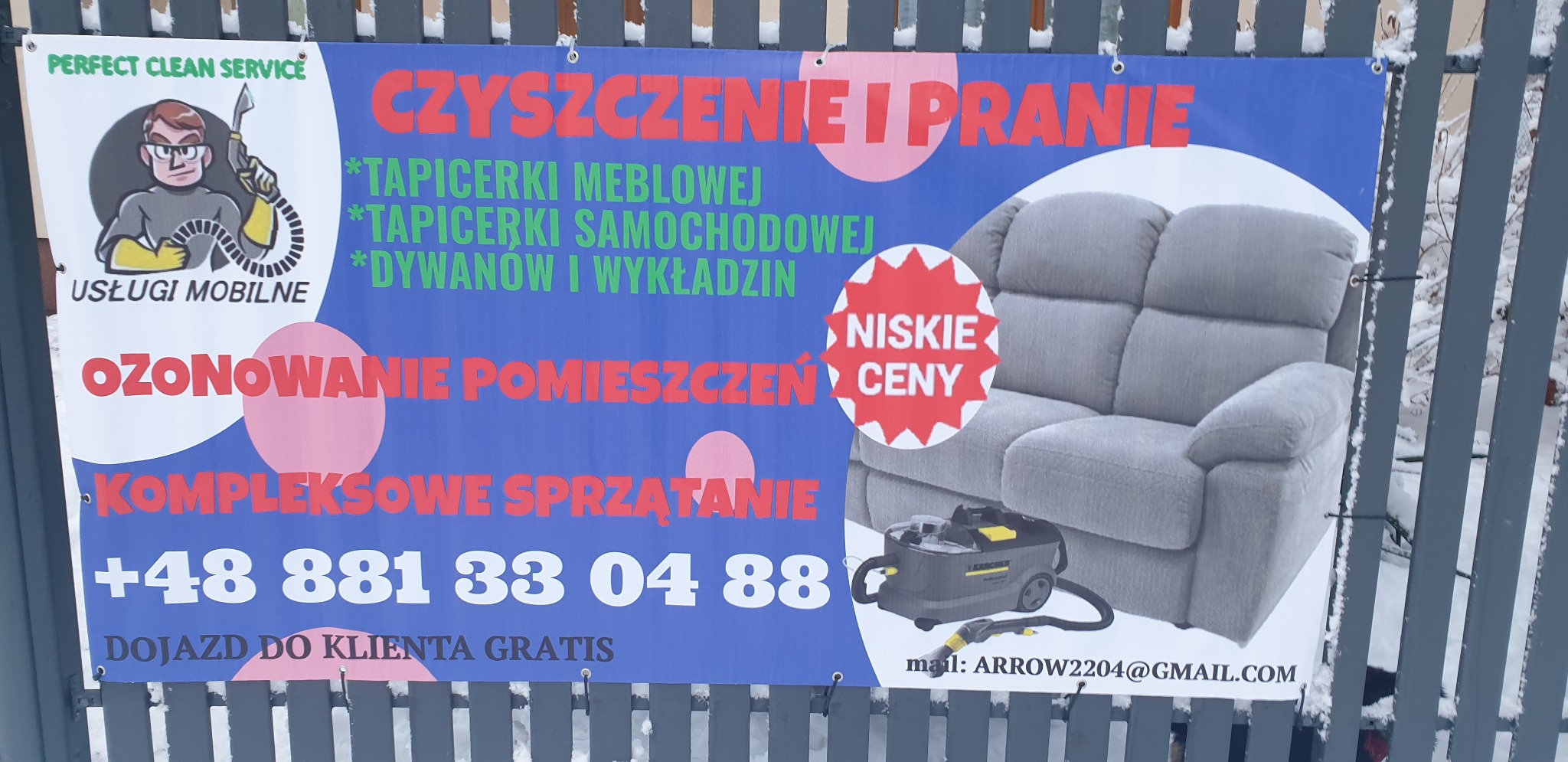 Baner reklamowy firmy oferującej usługi czyszczenia tapicerki meblowej i samochodowej, dywanów, ozonowania pomieszczeń i kompleksowego sprzątania, prezentujący szarą sofę i odkurzacz piorący.