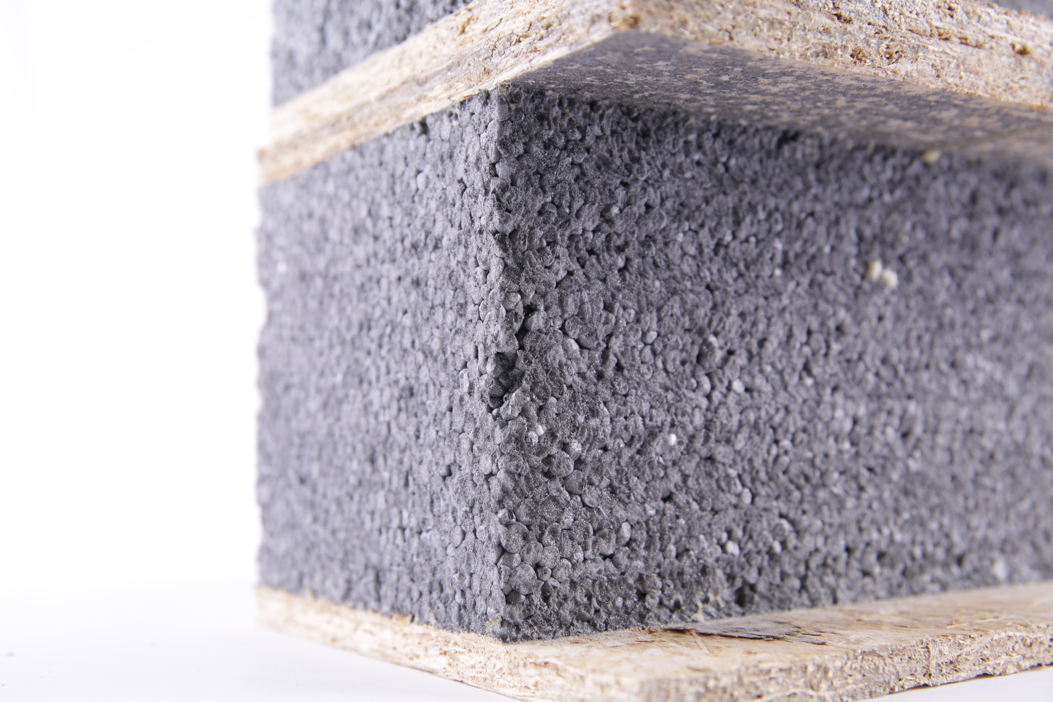 Fragment panelu SIP z widoczną warstwą izolacyjną z szarego styropianu pomiędzy dwiema płytami drewnopochodnymi.