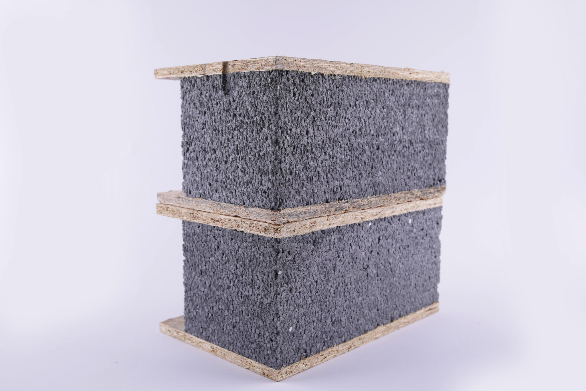 Dwa panele SIP ułożone jeden na drugim, widoczne struktura rdzenia z szarego styropianu i płyty OSB po bokach.