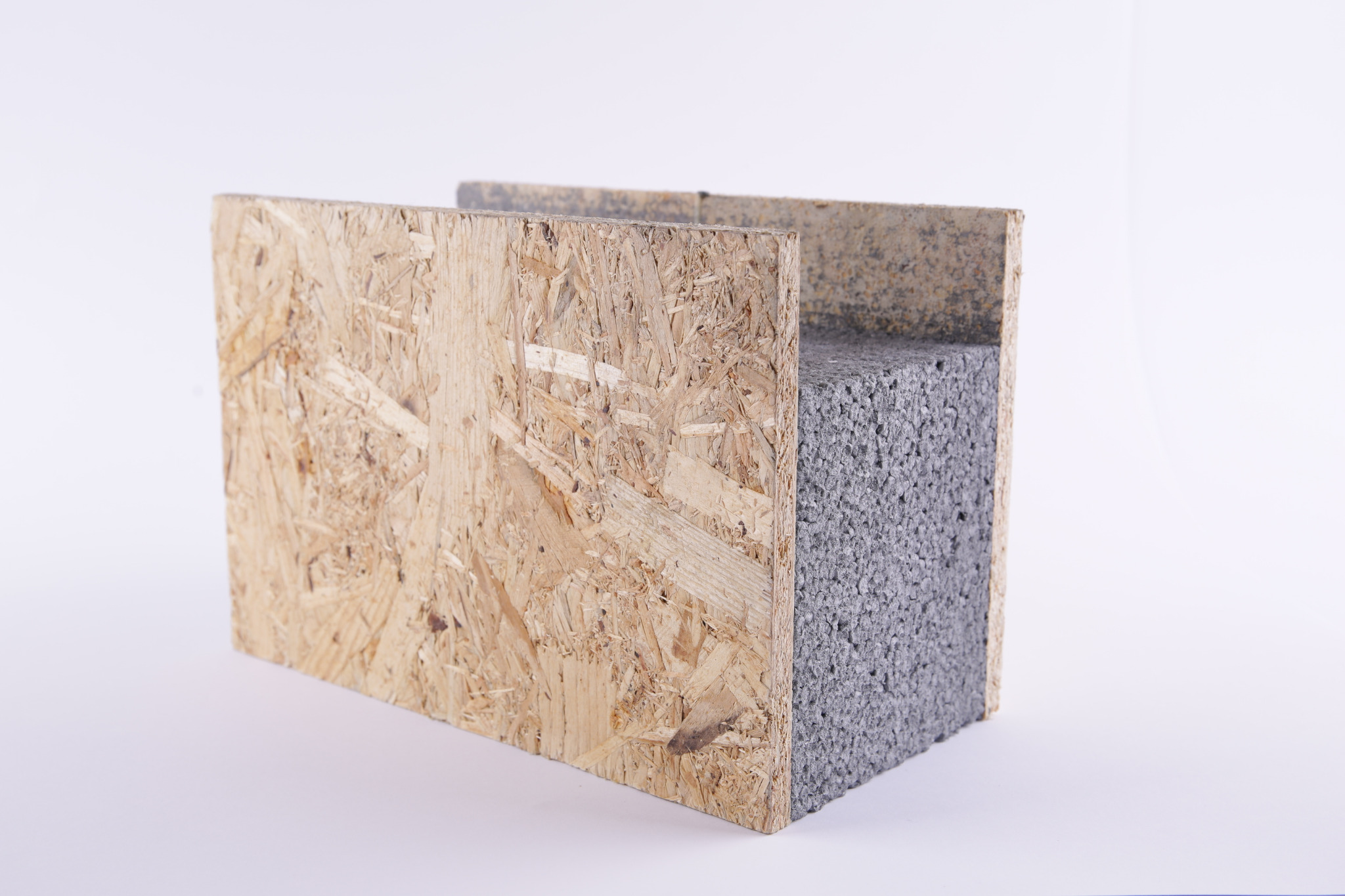 Przekrój panelu SIP: płyta OSB z widoczną warstwą izolacji styropianowej o szarej strukturze, na białym tle.