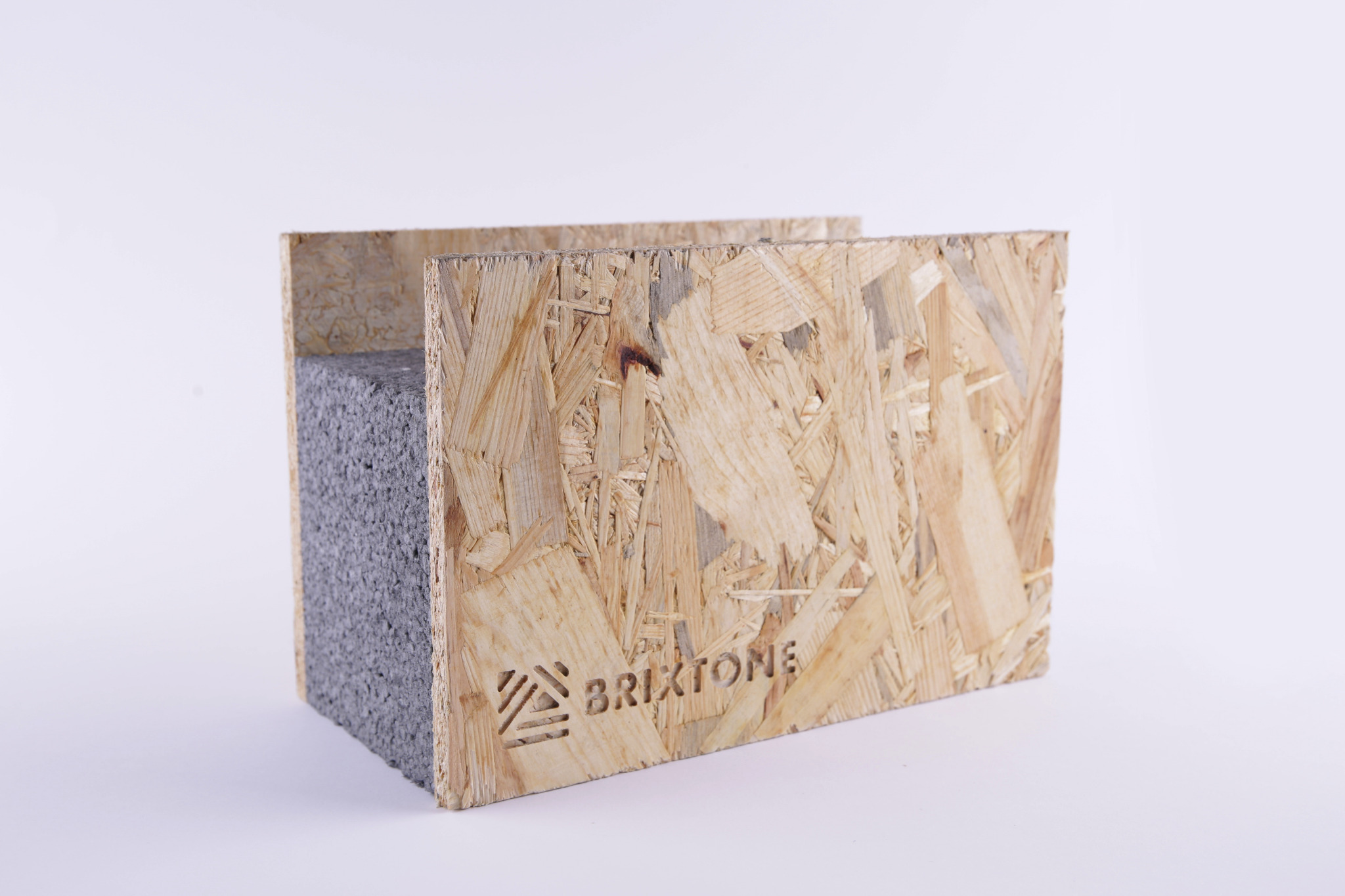 Przekrój panelu SIP z płyty OSB z wyciętym laserowo logo 'BRIXTONE', wypełnionego szarą pianką poliuretanową na białym tle.