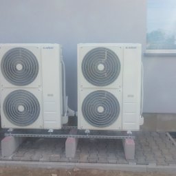 Klima-Rob Robert Majewski - Zewnętrzne jednostki klimatyzacyjne Kaisai zamontowane na betonowych blokach i metalowych szynach przy szarej ścianie budynku z widocznym oknem.