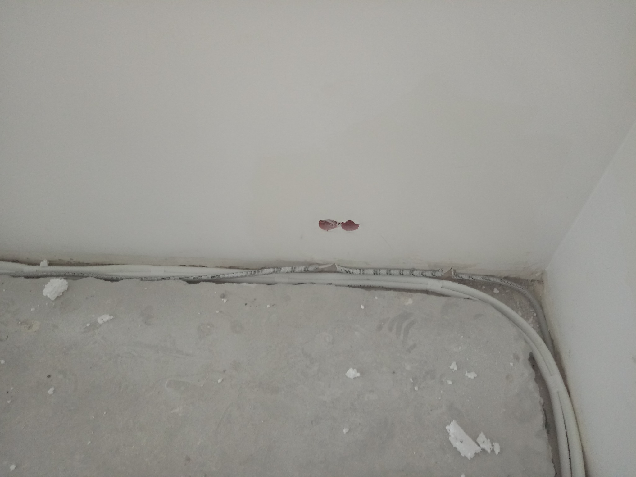 Przygotowanie do montażu instalacji elektrycznej pod klimatyzację: przewody elektryczne w korytach na podłodze, otwory w suficie na kable.