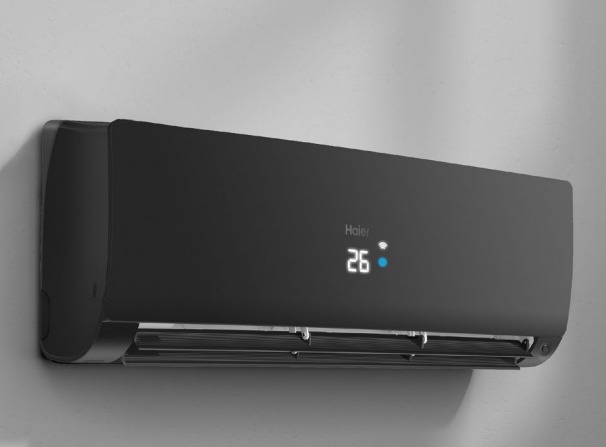 Czarny klimatyzator Haier z wyświetlaczem temperatury 26 stopni Celsjusza, zamontowany na szarej ścianie.