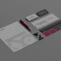 Zestaw materiał&oacute;w firmowych z logo w kolorze czerwonym: wizyt&oacute;wki, papier firmowy, koperta, długopis i klipsy na szarym tle.