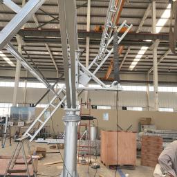 HM-SOLAR - Metalowa konstrukcja wsporcza w hali produkcyjnej, prawdopodobnie element systemu montażowego, z widocznymi narzędziami i elementami mocującymi na podłodze.