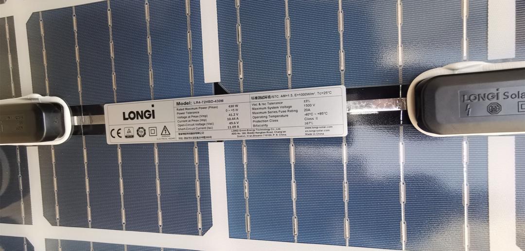 Panel słoneczny marki Longi z widoczną tabliczką znamionową zawierającą specyfikację techniczną, model LR4-72HBD-430M, oraz certyfikaty.