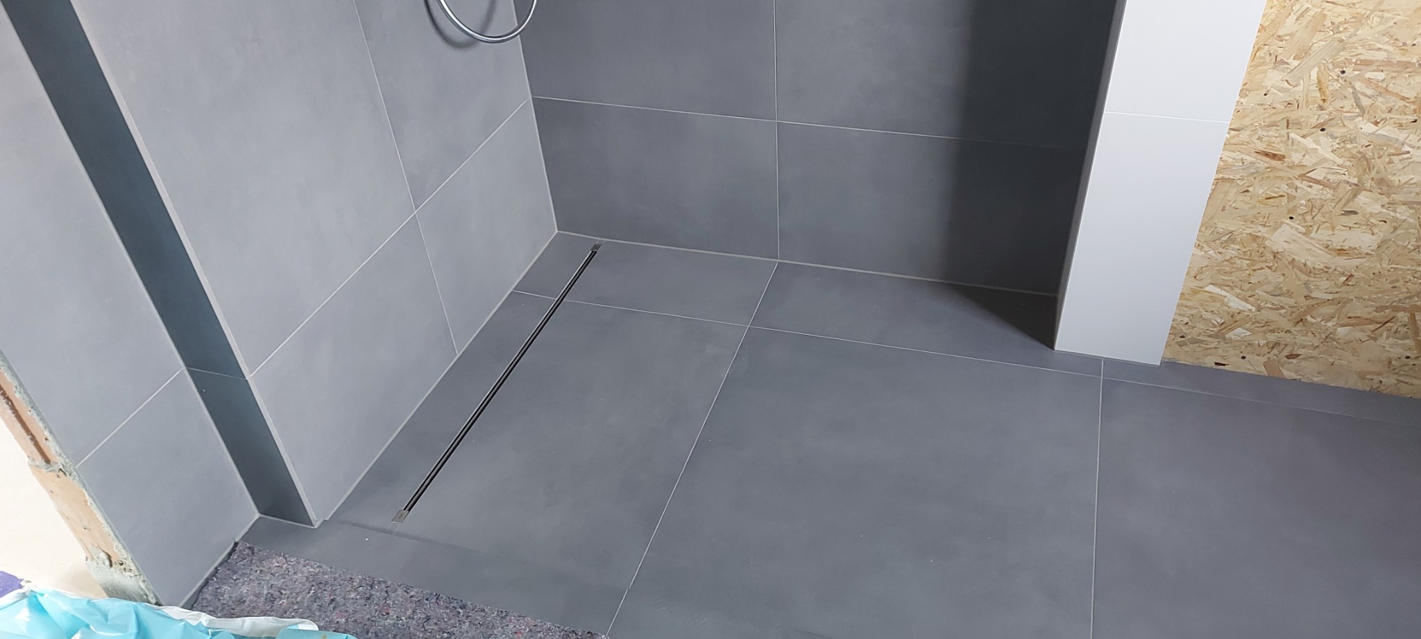 Prysznic z odpływem liniowym zamontowany od podstaw po biały montaż