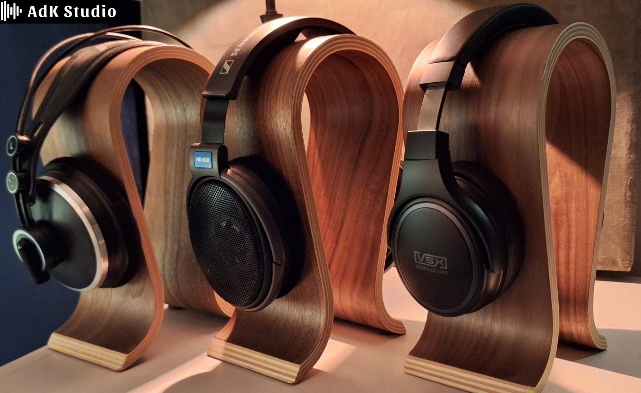 Trzy pary słuchawek studyjnych na drewnianych stojakach w Stanowicach. Modele Sennheiser HD 600 i VSX Steven Slate Audio. Profesjonalny sprzęt audio.