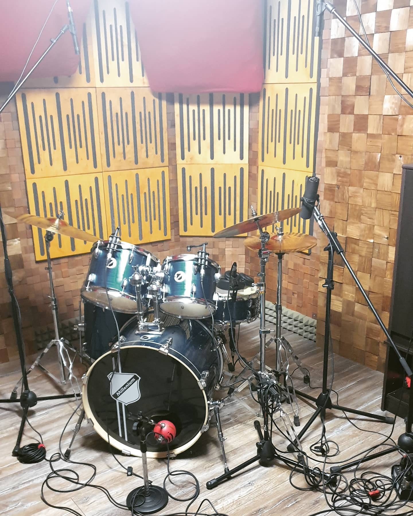 Perkusja Millenium w profesjonalnym pomieszczeniu z panelami akustycznymi i mikrofonami, gotowa do nagrania.