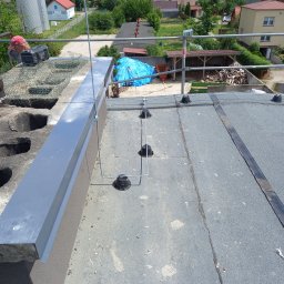 P.H.U. Dr Volt Zbigniew Frejman - Montaż instalacji odgromowej na dachu w Bakałarzewie. Widoczne elementy mocujące i przewody. Praca na wysokości, zabezpieczenia rusztowaniami.
