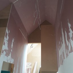 P.H.U. Dr Volt Zbigniew Frejman - Wnętrze w trakcie remontu: ściany z płyt gipsowo-kartonowych, częściowo zaszpachlowane, widoczne przewody elektryczne i konstrukcja poddasza.