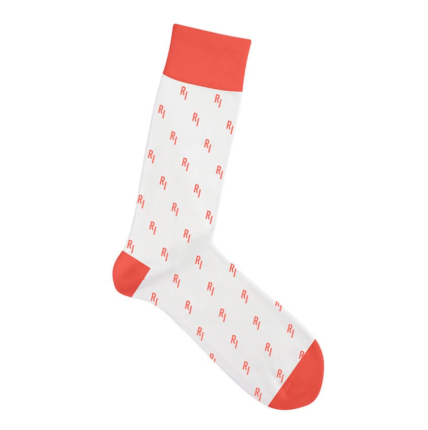 Pojedyncza biała skarpetka z czerwonymi wzorami 'R1' i czerwonym ściągaczem oraz palcami, leżąca na białym tle.
