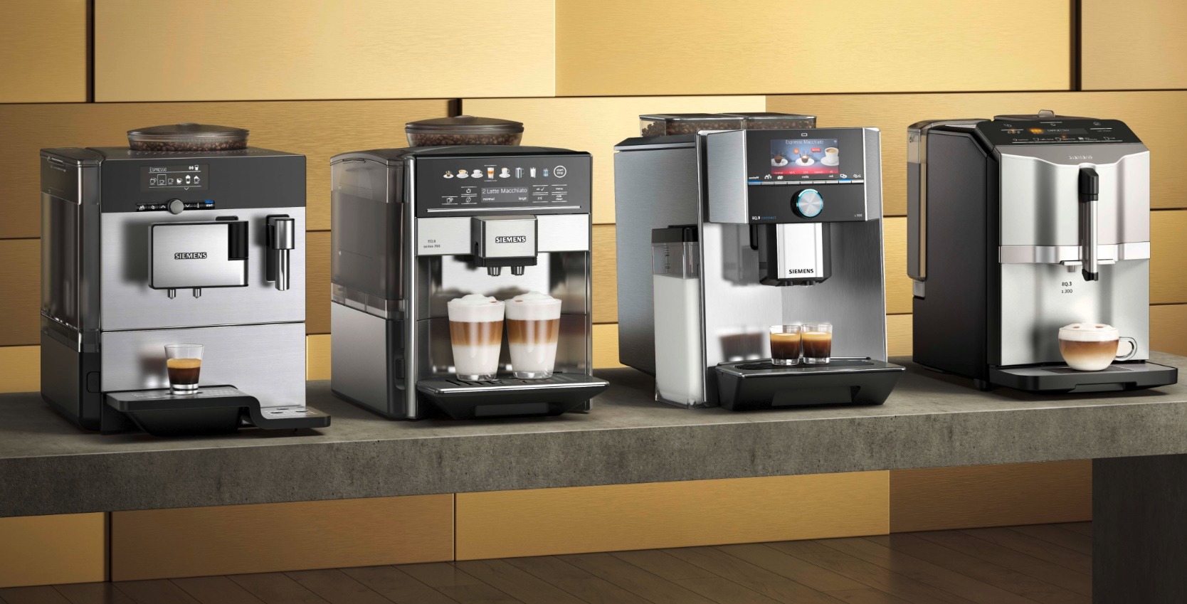 Cztery automatyczne ekspresy do kawy marki Siemens, modele EQ.9, EQ.6 i EQ.3, prezentowane na blacie z napojami w szklankach i filiżankach, na tle ściany z drewnianych paneli.