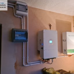 freeDOM fotowoltaika Marcin Szałacki - Instalacja fotowoltaiczna wewnątrz budynku: rozdzielnice, inwerter Deye i magazyn energii GSL Energy, z widocznymi przewodami i rurami instalacyjnymi.