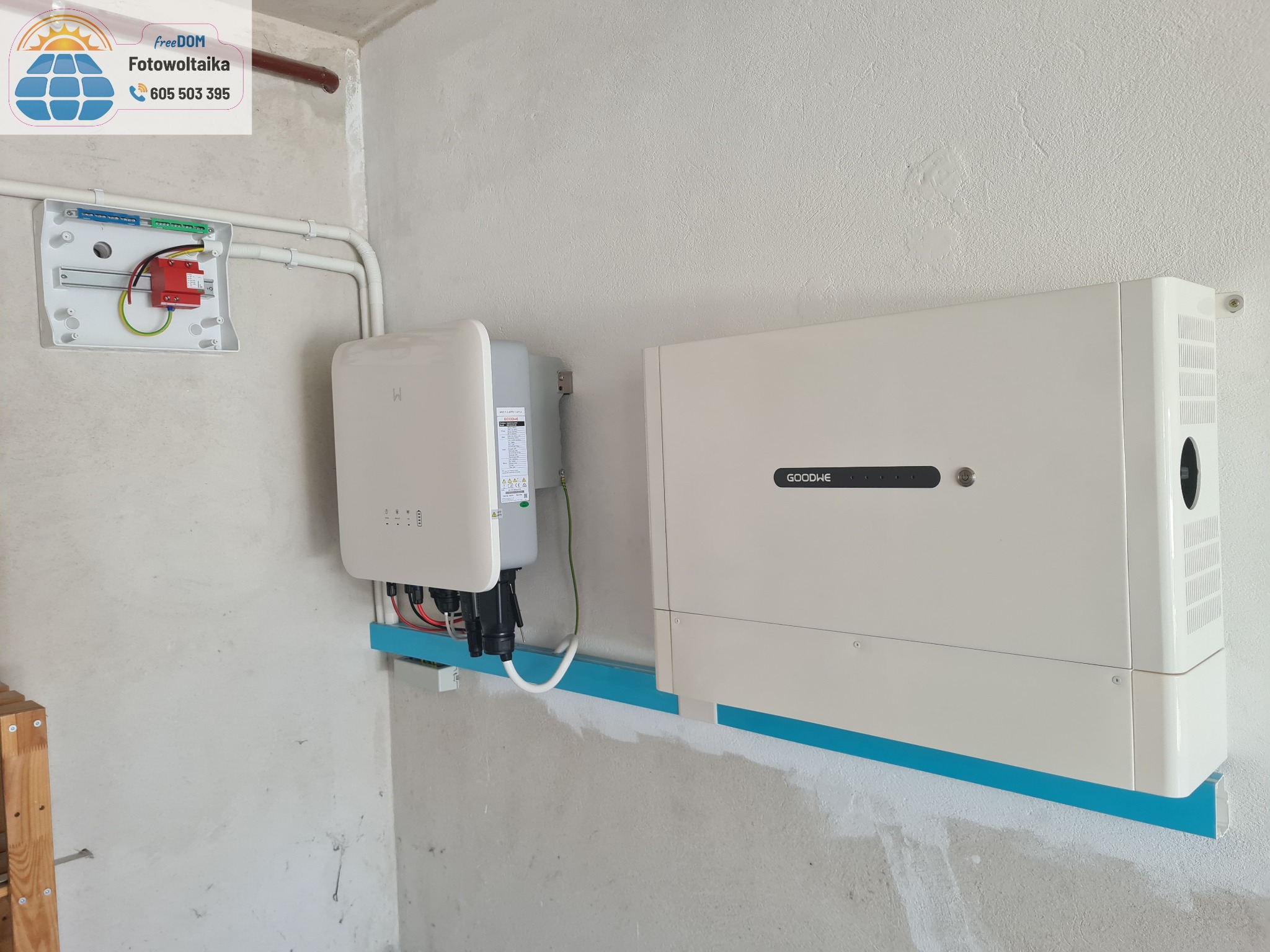 Zamontowana instalacja fotowoltaiczna wewnątrz budynku. Widoczne inwertery GoodWe i zabezpieczenia elektryczne. Montaż na niebieskiej listwie.