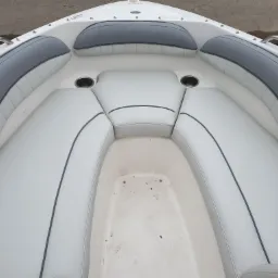 Wnętrze łodzi motorowej z białymi skórzanymi siedzeniami z szarymi akcentami i uchwytami na napoje, widok z góry.