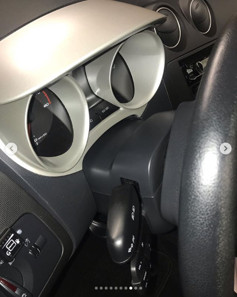 Wnętrze samochodu z widocznym kokpitem, kierownicą i elementami sterowania, sfotografowane z perspektywy kierowcy.