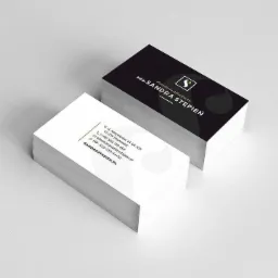 Stos wizytówek adwokata Sandry Stępień, z czarnym tłem na górnej wizytówce, prezentujące logo i dane kontaktowe.