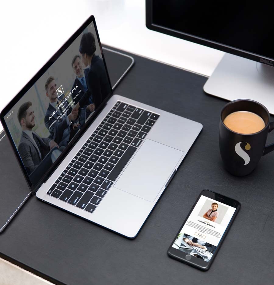 Laptop i smartfon wyświetlające strony internetowe adwokata Sandry Stępień, obok czarny kubek z logo na czarnym biurku.