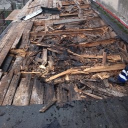 PAMADACH Paweł Maciejczyk - Uszkodzona konstrukcja dachu z widocznymi fragmentami desek i połamanych elementów, częściowo zdemontowana, ukazująca stan przed naprawą lub wymianą.