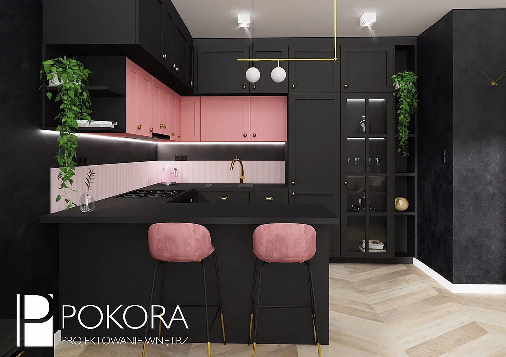 Nowoczesna kuchnia w czerni i pudrowym różu z dwoma welurowymi hokerami przy wyspie, złote akcenty w oświetleniu i armaturze, parkiet ułożony w jodełkę.