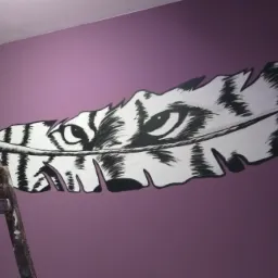 Ręcznie malowane na fioletowej ścianie pióro z motywem tygrysa, widoczna drabina malarska w lewym dolnym rogu.