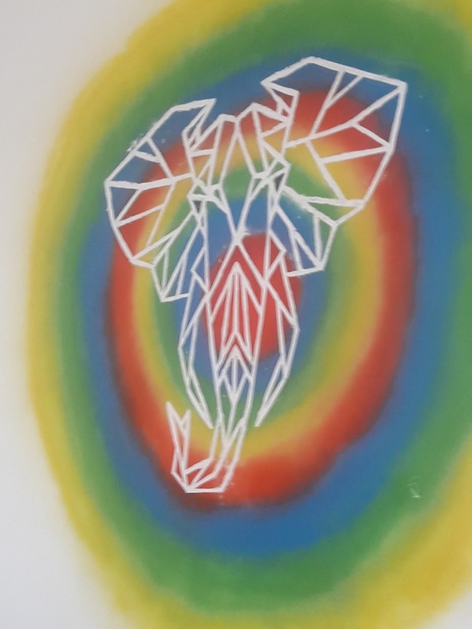 Geometryczny, biały kontur słonia na rozmytym, tęczowym tle, przypominającym malunek na ścianie.