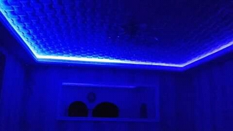 Podwieszany sufit z efektem pikseli i oświetleniem LED w intensywnym odcieniu niebieskiego, tworzący nowoczesny design wnętrza.