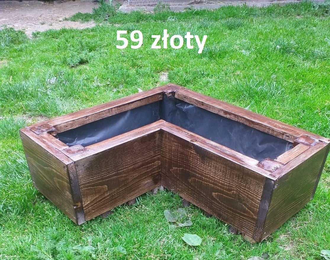 Kanciasta, brązowa, drewniana donica z czarnym wkładem na tle zielonej trawy. Widoczne słoje drewna. Cena 59 zł.