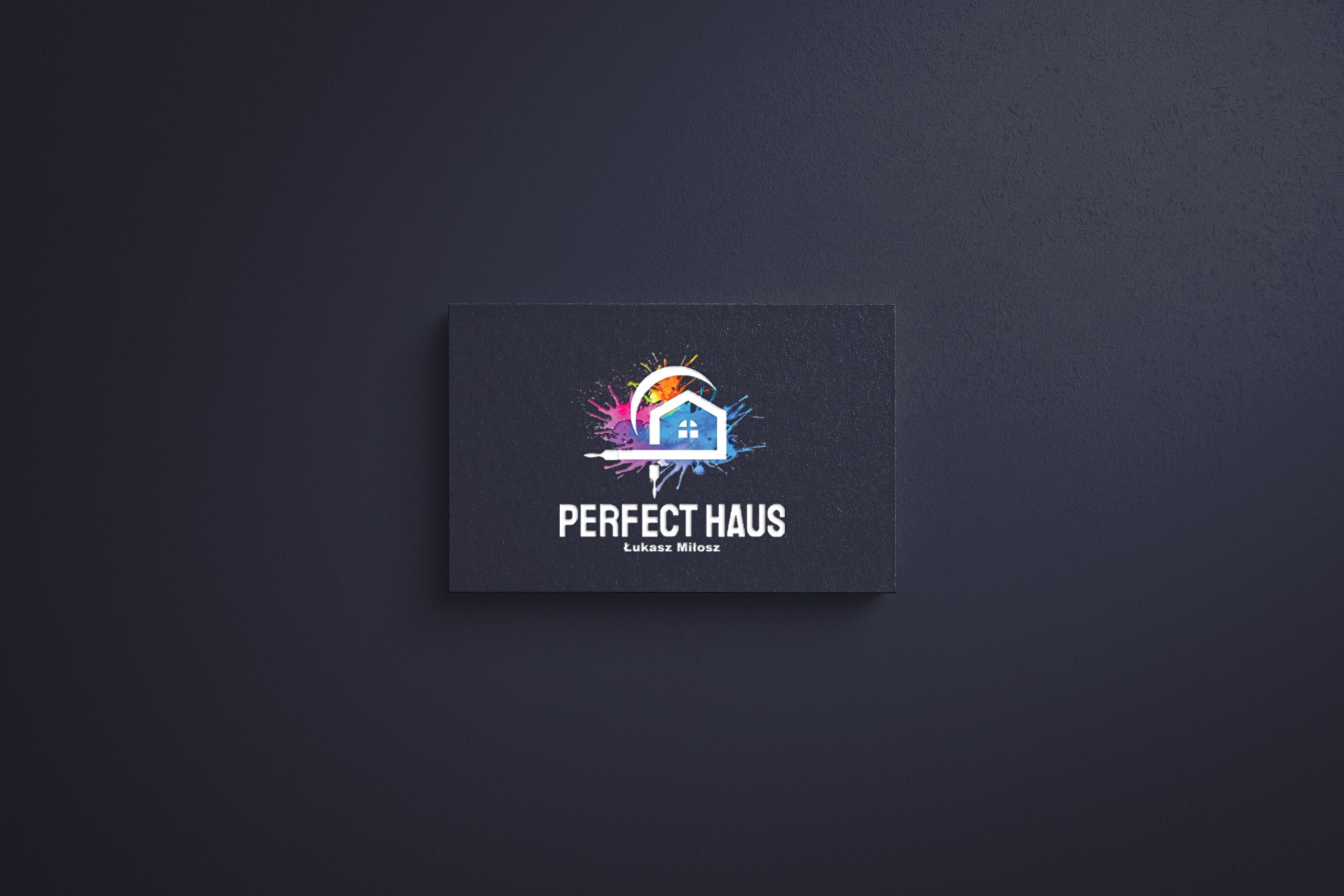 Wizytówka firmy budowlanej Perfect Haus z logo przedstawiającym dom z farbami, na ciemnym tle.