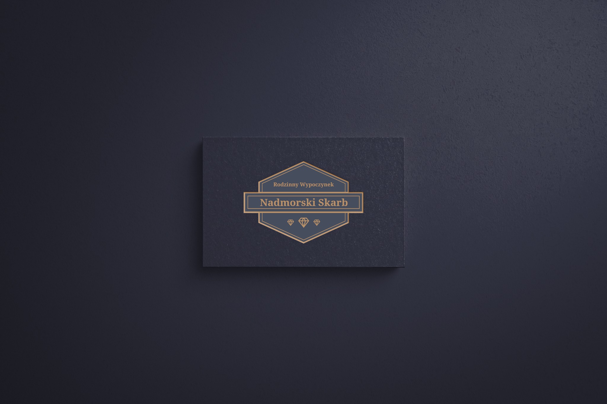 Wizytówka z logo 'Rodzinny Wypoczynek Nadmorski Skarb' w kolorze złotym na ciemnoniebieskim tle z teksturą.