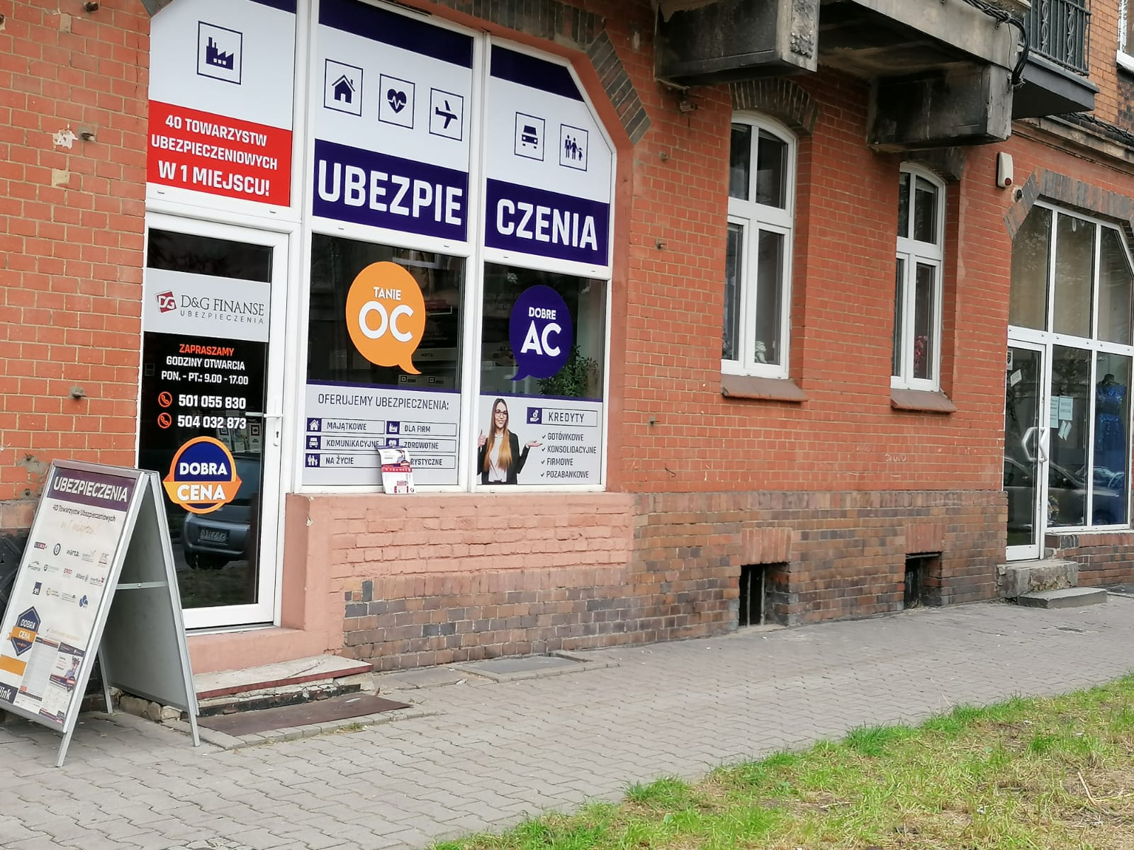 Fasada budynku z szyldem 'D&G Finanse Ubezpieczenia', oferującego ubezpieczenia majątkowe, komunikacyjne, na życie, dla firm, zdrowotne i turystyczne, a także kredyty gotówkowe, konsolidacyjne...