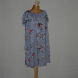 Letnia sukienka w paski z motywem róż, zaprezentowana na drewnianym manekinie na tle szarej ściany.