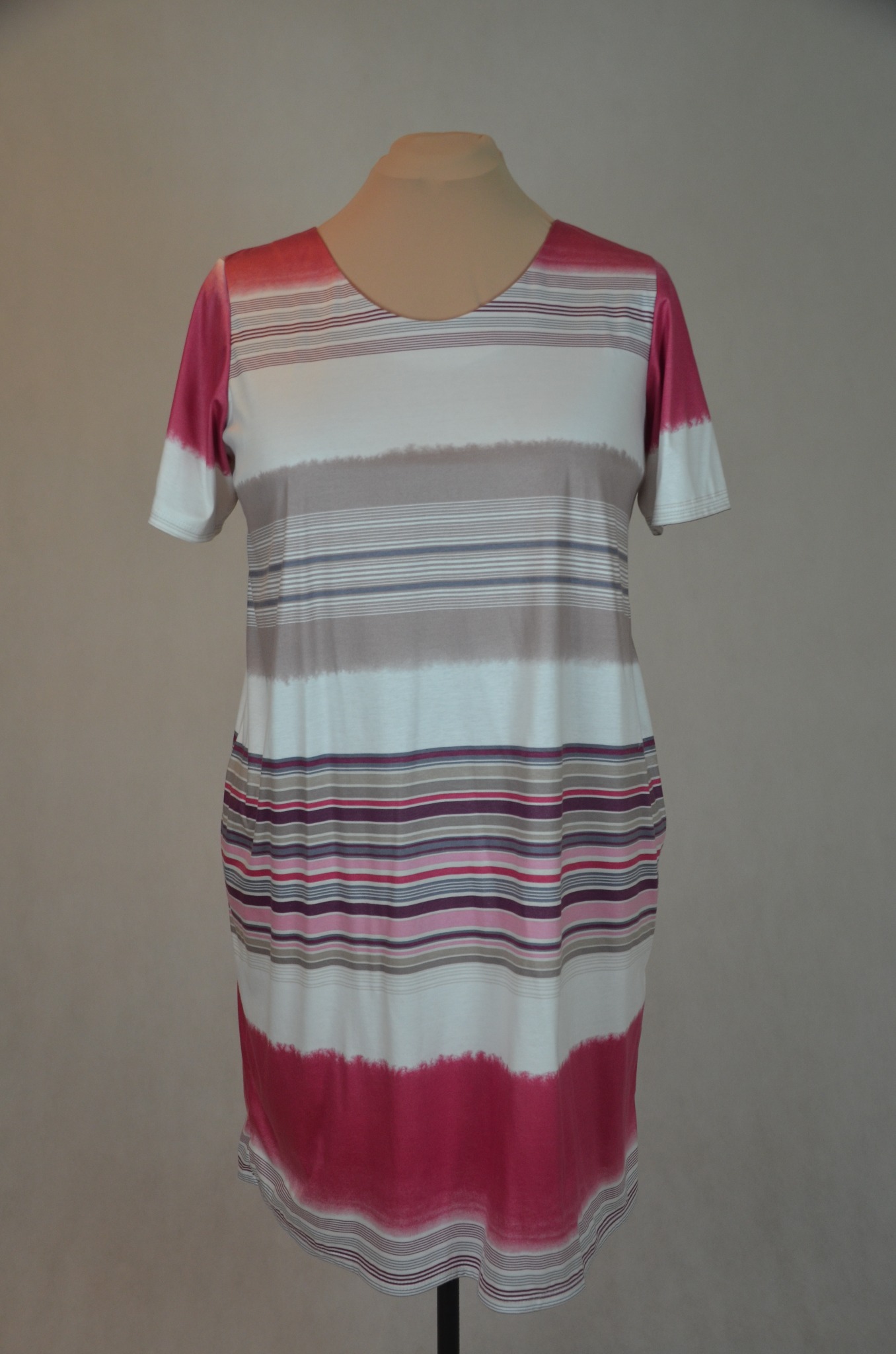 Letnia sukienka XXL w poziome paski w odcieniach różu, szarości i bieli, prezentowana na manekinie na neutralnym tle.