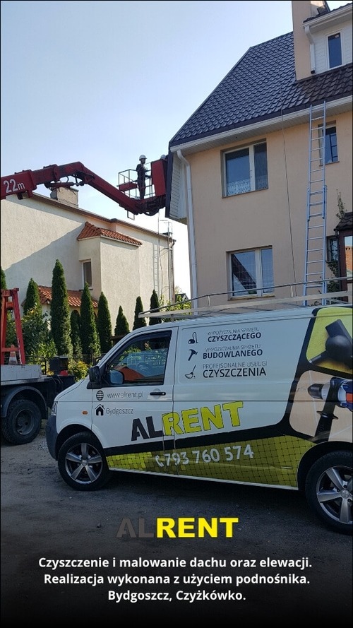 Pracownik w podnośniku koszowym czyści elewację domu jednorodzinnego, widoczny samochód firmowy z reklamą usług czyszczenia i malowania elewacji oraz dachu.