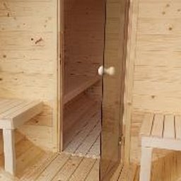 ABELIX Kamil Pawluk - Drewniana sauna beczka z otwartymi drzwiami, widoczne wnętrze z ławkami, jasne drewno, naturalne oświetlenie.