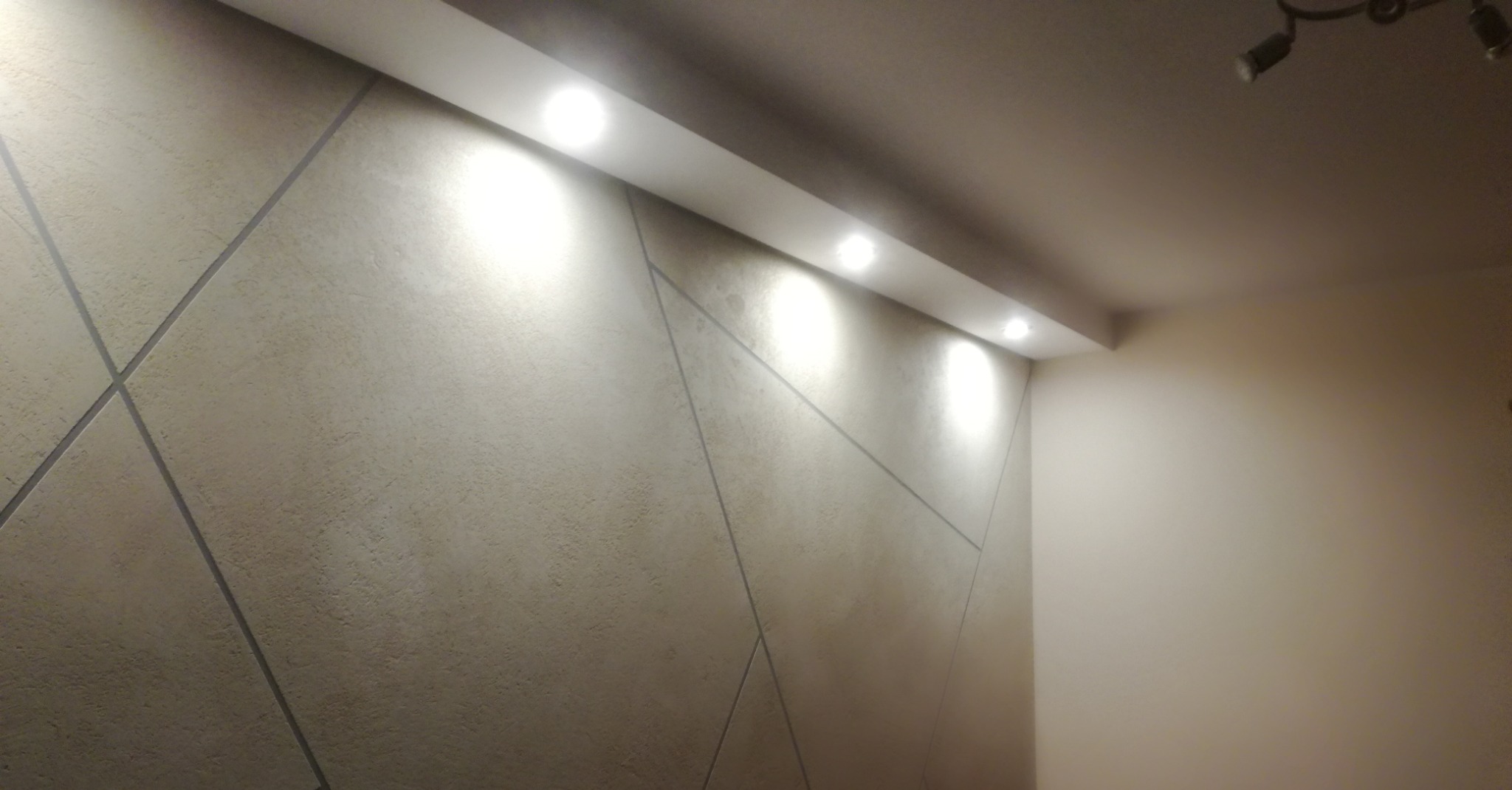 Efekt betonu dekoracyjnego z zabudową LED i halogenami