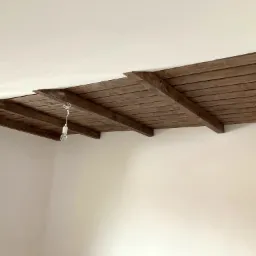 Obniżenie poddasza przy zastosowaniu belek drewnianych oraz boazerii.