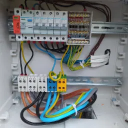 Rozdzielnica elektryczna z zabezpieczeniami i okablowaniem w białej obudowie, zamontowana w Myczkowie, widoczne szczegóły połączeń i komponenty Hager oraz Simtec.