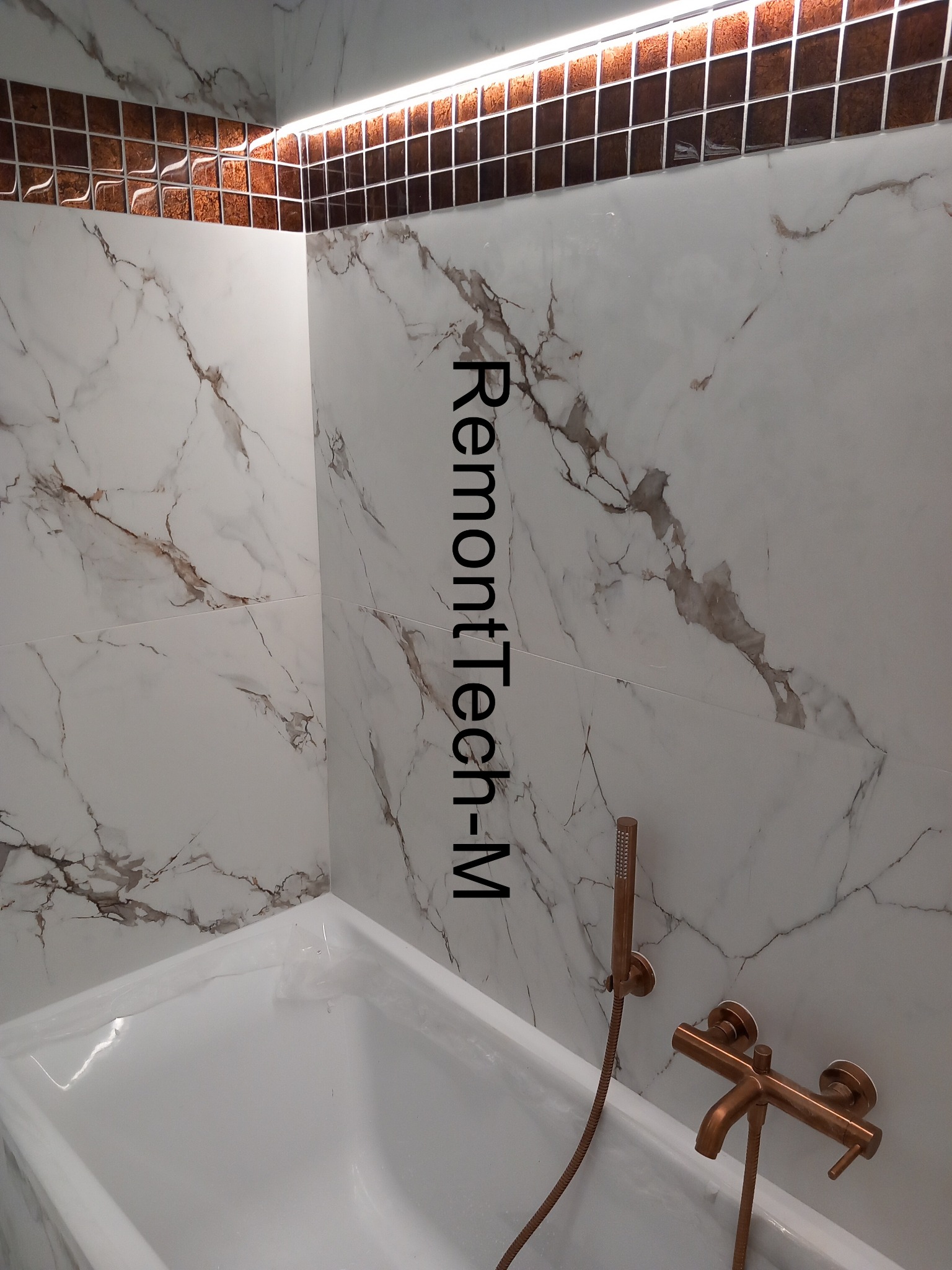 Biała wanna z marmurowymi płytkami i dekoracyjnym, brązowym pasem mozaiki pod sufitem, oświetlonym ledami. Bateria w kolorze miedzi dopełnia wystrój.