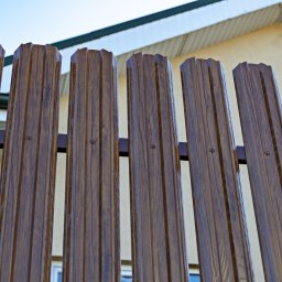 Ogrodzenie ze sztachet metalowych Hanbud, jednostronne, montowane pionowo, drewnopodobne. 