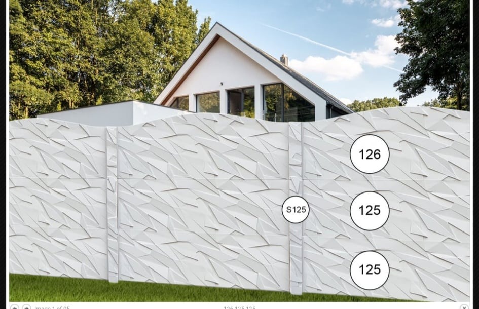 Nowoczesne, białe ogrodzenie z betonu architektonicznego o trójwymiarowej, geometrycznej fakturze, na tle minimalistycznego domu z dużymi oknami i zieleni.