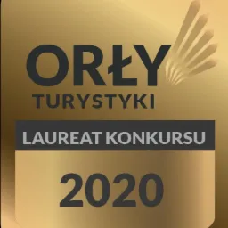 Złota odznaka 'Orły Turystyki' z napisem 'Laureat Konkursu 2020' na czarnym tle.