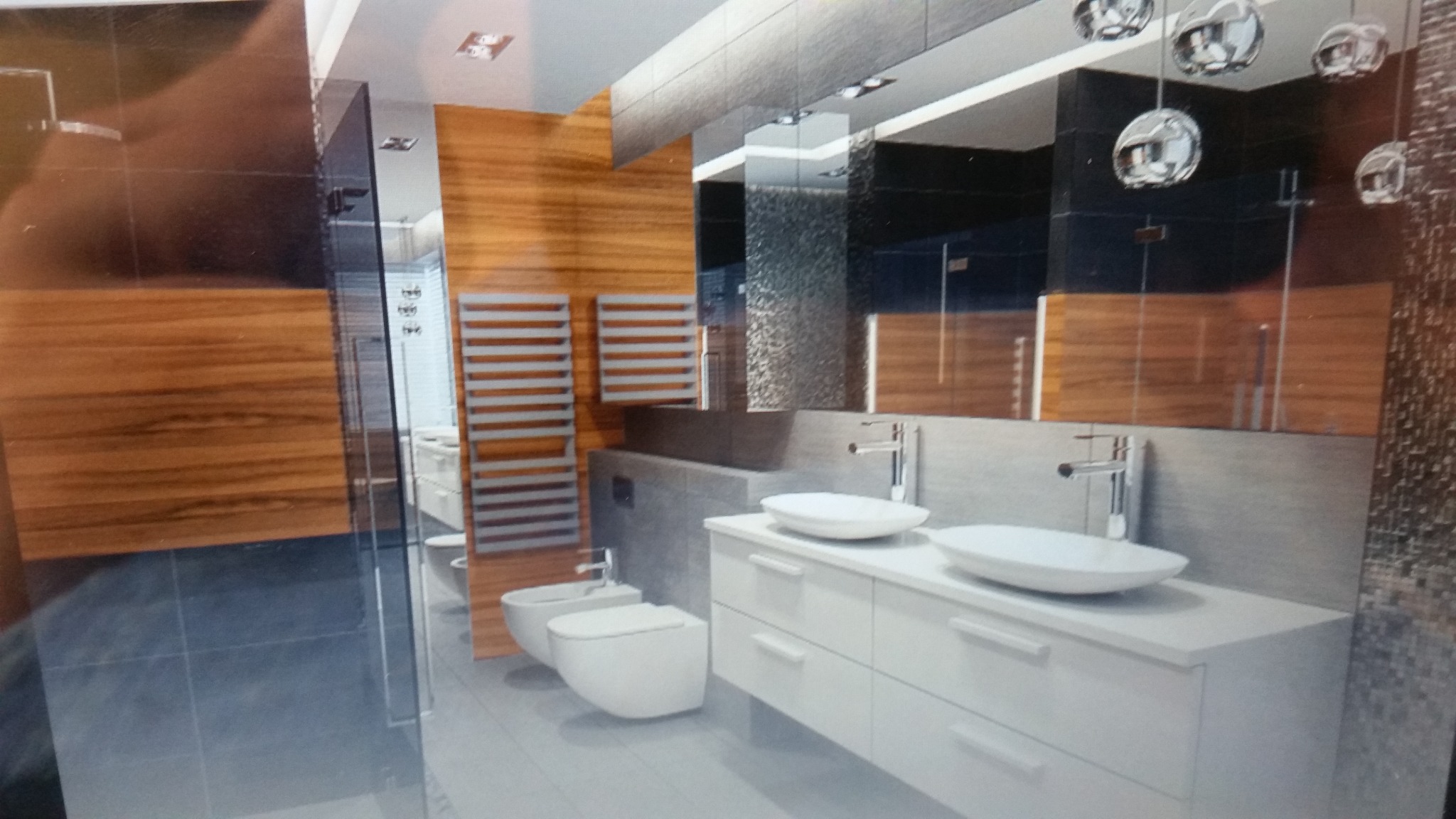 Nowoczesna łazienka z drewnianymi panelami, grzejnikami drabinkowymi, białymi umywalkami nablatowymi i toaletą wiszącą, oświetlona designerskimi lampami sufitowymi.