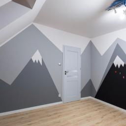 Express Remont - Pokój dziecięcy na poddaszu z pomalowanymi ścianami w motywie gór, białe ściany z szarymi i czarnymi trójkątami imitującymi góry, drewniana podłoga, szare drzwi z przeszkleniem, sufit ze skośnym...