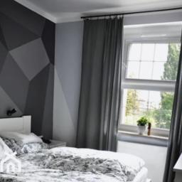Express Remont - Sypialnia z geometrycznym wzorem w odcieniach szarości na ścianie, szare zasłony i biała pościel w kwiatowy wzór.
