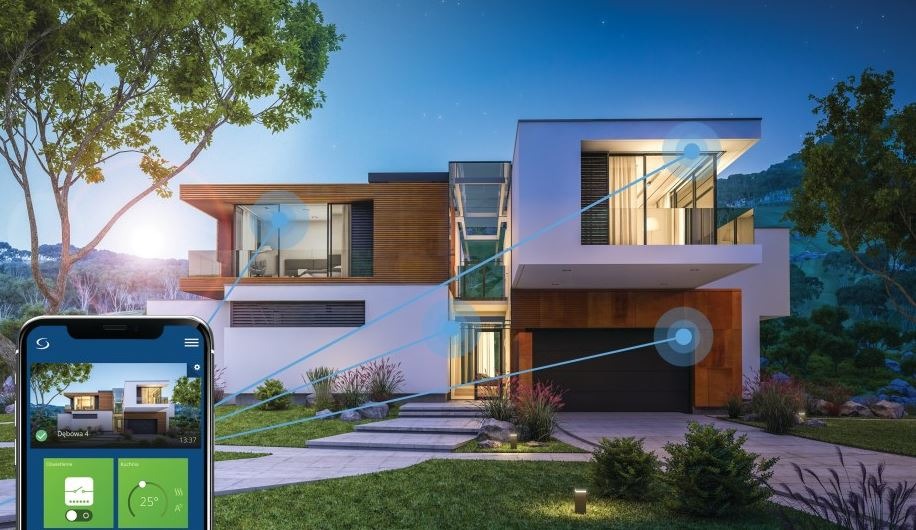 Nowoczesny dom z płaskim dachem, oświetlony wieczorem, sterowany za pomocą aplikacji na smartfonie, z widocznymi połączeniami między urządzeniami.