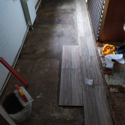 Położenie płytek podłogowych w kuchni otwartej z salonem.
Wykonanie progu z listwą aluminiową aby zapobiec wykruszanie płytek